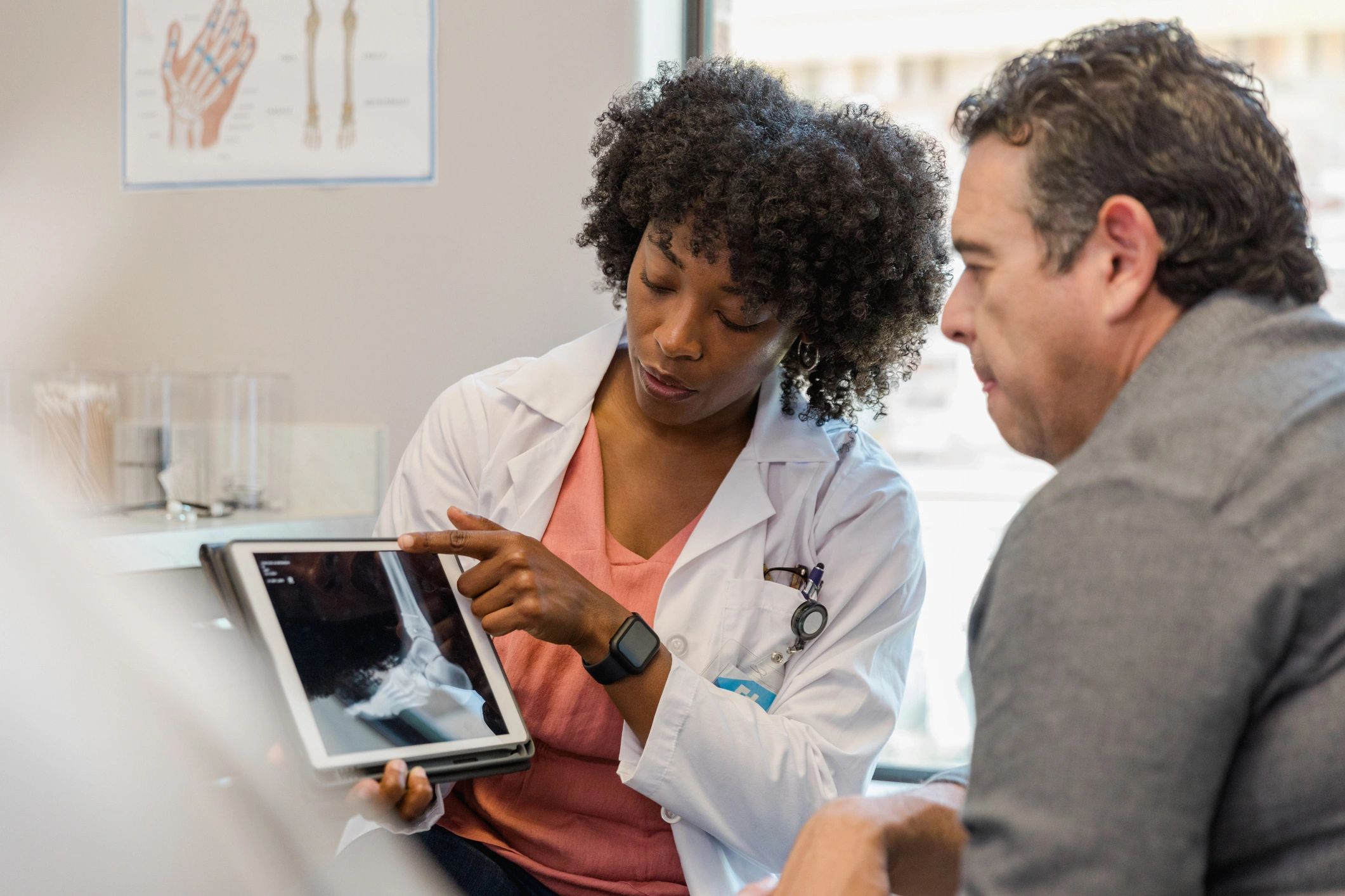 Clinician reviewing results with a patient on a tablet during a consultation